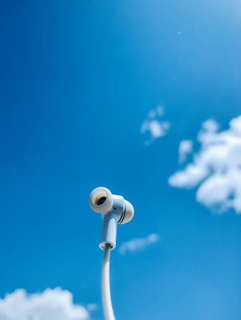 Generative AI : belly of pregnant woman and headphones on the sky backgroundの素材