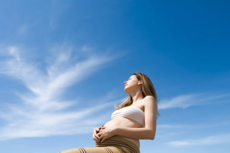 Generative AI : belly of pregnant woman and headphones on the sky backgroundの素材