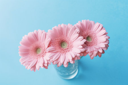 Generative AI : Colorful gerbera flowers floating in a bowl with water Blue stone background Top view Copy spaceの素材