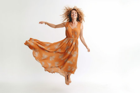 Beauty in the air Full length studio shot of attractive young woman in orange dress hovering in air and smiling : Generative AIの素材
