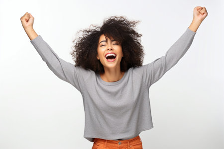 Everyday winner Excited young African woman keeping arms raised and expressing positivity while standing against grey background : Generative AIの素材