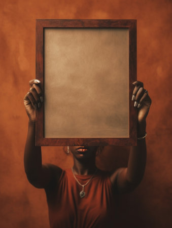 Happy African woman holding a fluffy frame while standing against brown background : Generative AIの素材