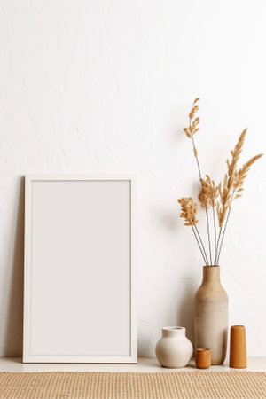 Wooden picture frame with a branch of pinetree and red flower on a white brick background : Generative AIの素材