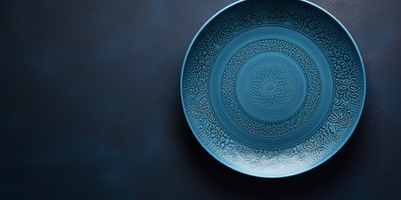 Blue ceramic plate with beautiful pattern. Dark blue textured background with copy space. Modern tableware close up photo. : Generative AIの素材