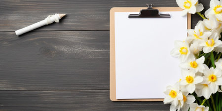 A wooden folder for documents with an iron clothespin and a white sheet of Mocap paper with spring flowers of narcissus and a sprig of gypsophila. White brick background. : Generative AIの素材