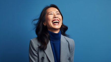 Active joyful stylish female teacher retires wears hat and formal jacket glad receiving congratulation from colleagues has charming smile on face isolated on blue wall co : Generative AIの素材