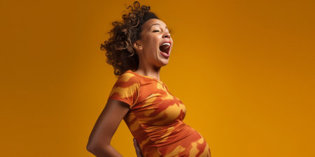 Preparing for child birth Cheerful pregnant African American woman points at sad husband who holds baby stuff get ready to become parents isolated over yellow background  : Generative AIの素材