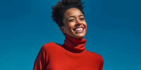 Portrait of satisfied dark skinned female model with Afro haircut gentle smile dressed in casual orange jumper looks straightly at camera pose over blue studio wall for m : Generative AIの素材