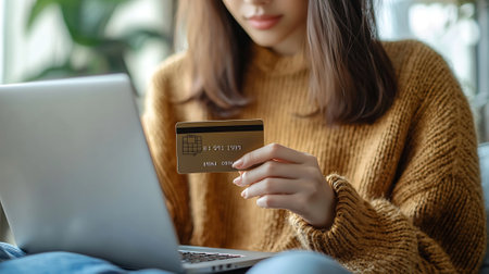 Close up of woman holding credit card and using laptop for online shoppingの素材