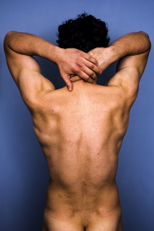 Rear view of topless man with hands behind his neckの写真素材