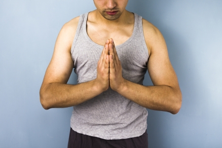 Young ethnic man in praying yoga poseの写真素材