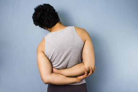 Young multiracial man stretching his back and shouldersの写真素材