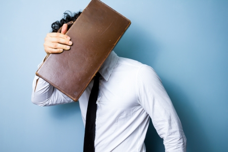 Businessman hiding behind his briefcaseの写真素材