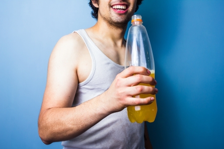 Young man drinking energy drink after a sweaty workoutの写真素材