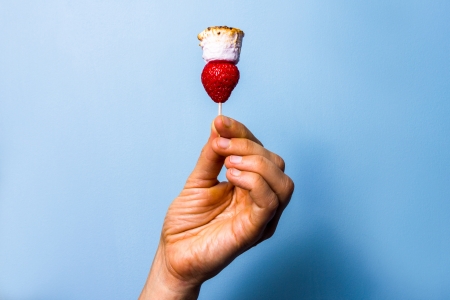 Hand holding marshmallow and strawberryの写真素材