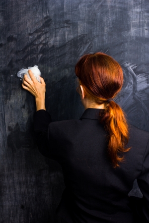 Redhead businesswoman wiping her slate cleanの写真素材