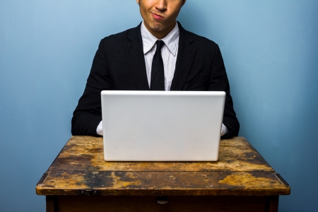 Confused businessman working on computerの写真素材