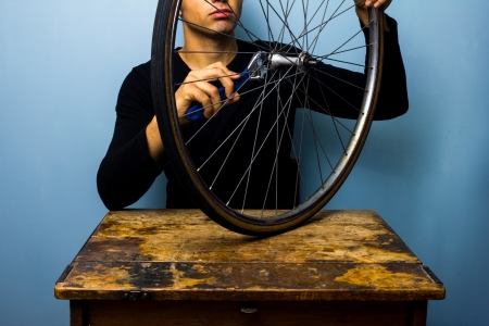 Young man is fixing bicycle tyreの写真素材