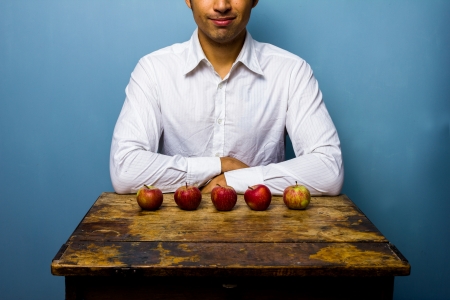 Man with five apples in front of himの写真素材