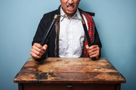 Thug at table with nunchucksの写真素材