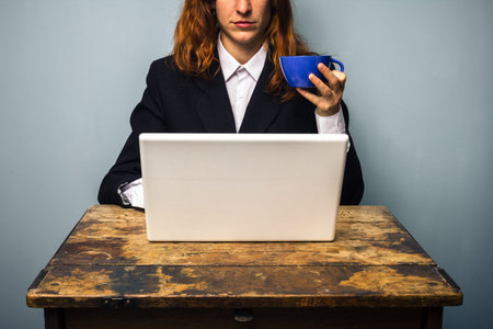 Business woman with laptop drinking coffee