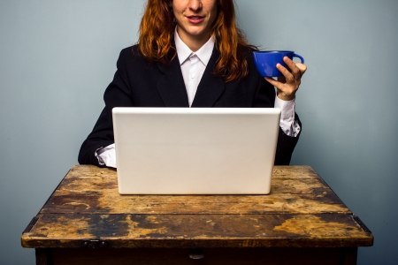 Business woman with laptop drinking coffeeの写真素材