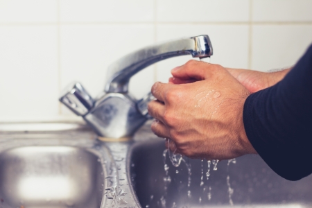 Man washing his hands in sinkの写真素材