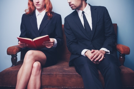 Businesswoman and businessman wating on sofaの写真素材