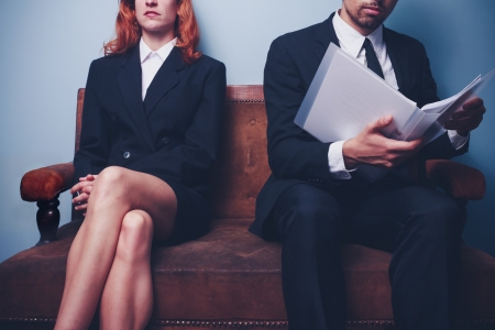 Businesswoman and businessman wating on sofaの写真素材