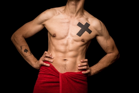 Athletic and muscular young man posing on black backgroundの写真素材
