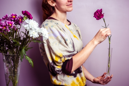 Young woman arranging a bouquet of colorful flowersの写真素材