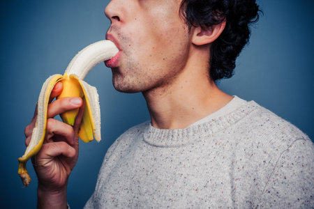 Young man is eating a banana