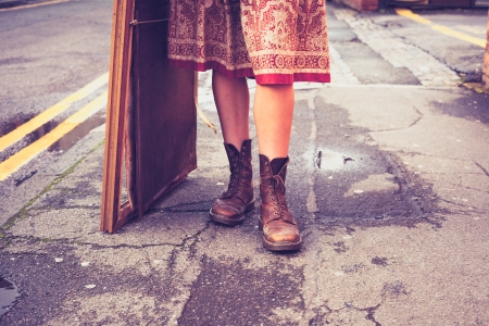 Legs of a young woman standing in street with picture frameの写真素材