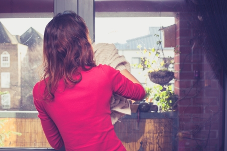 Young woman cleaning her windowsの写真素材