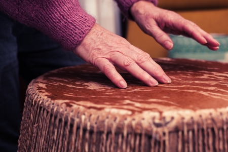 Old woman playing the bongo drumsの写真素材