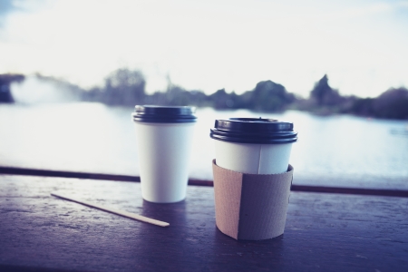 Two paper cups by the lake at sunset in winterの写真素材