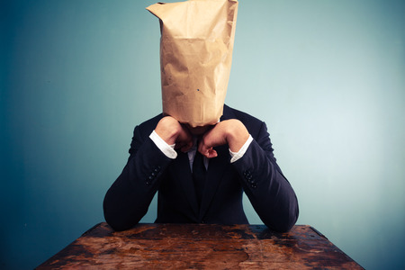 Businessman with bag over his head is upsetの写真素材