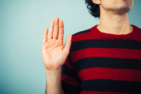 Young ethnic man is pledging allegience with his right hand raisedの写真素材