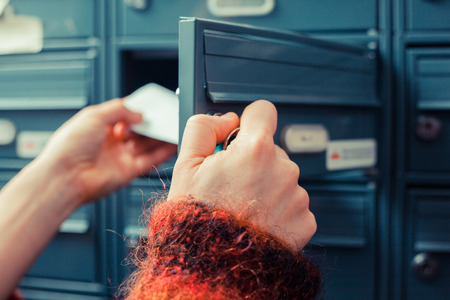 Closeup on a woman's hand as she is getting her post out of her letterboxの写真素材