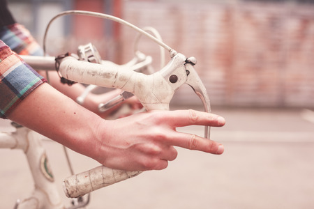 Young woman is riding a bike, closeup on her handsの写真素材