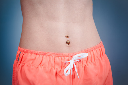 A fit young woman with a toned belly is wearing pink workout shortsの写真素材