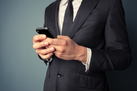 A young businessman is using his smart phoneの写真素材