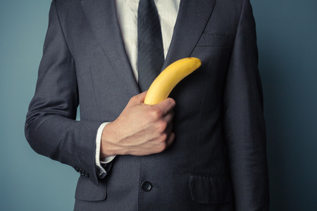 Young businessman is holding a bananaの写真素材