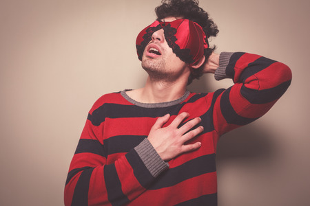A young man wearing a bra on his face is touching his chestの写真素材