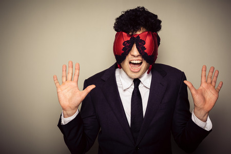 Businessman with lingerie on his face is caught comitting adulteryの写真素材