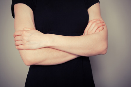 Young woman is standing with her arms crossedの写真素材