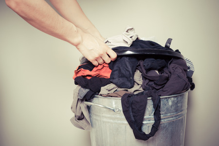 Young woman is sorting out her laundry at homeの写真素材