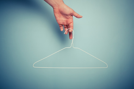A Hand is holding a wire hangerの写真素材