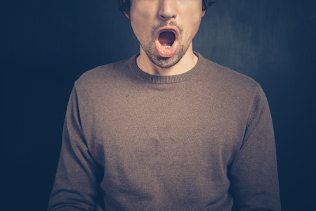 Surprised young man with his mouth openの写真素材