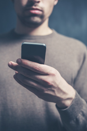 A young man is using a smart phoneの写真素材